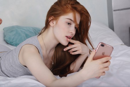 Радостная Jia Lissa расслабляется на кровати