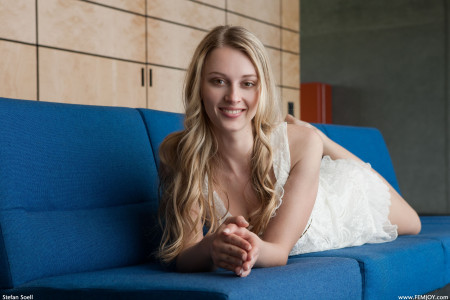 Счастливая блондинка позирует голая на диване