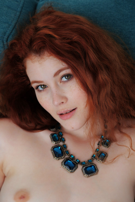 Молодая модель позирует голая на диване